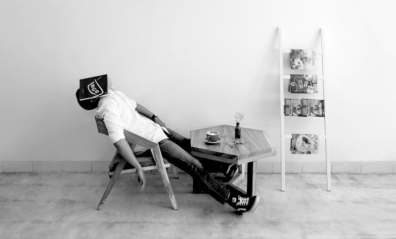 Man with book covering face