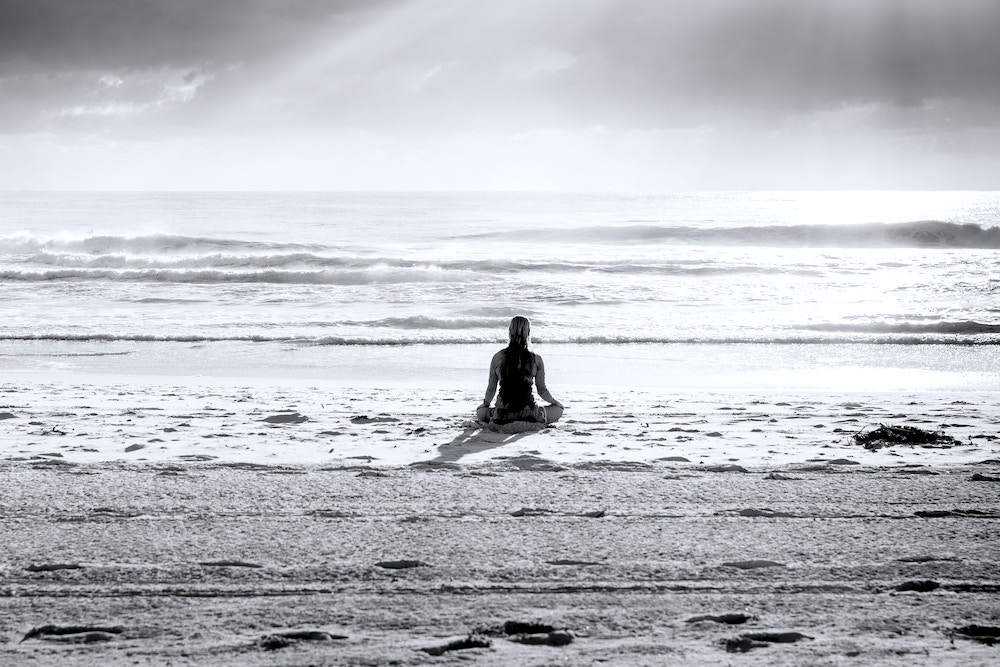 Girl meditating on beach