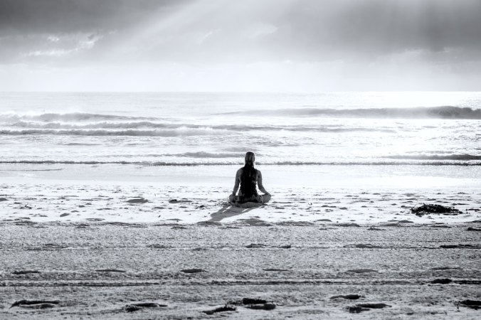 Girl meditating on beach