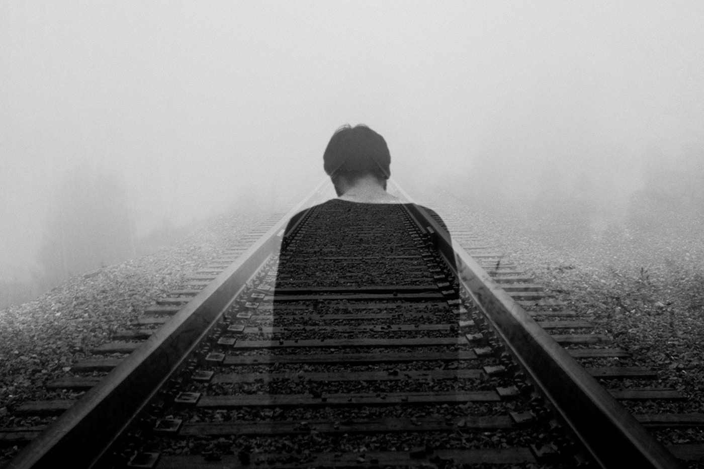A man disappearing along train tracks