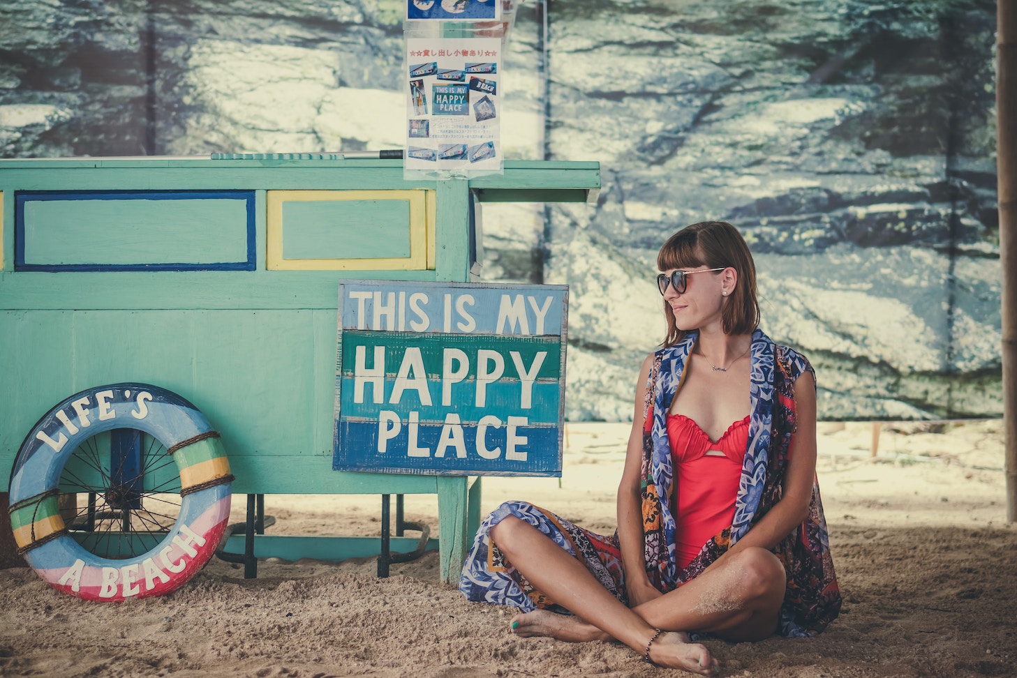 Woman sitting before sign that says 'This is my happy place'