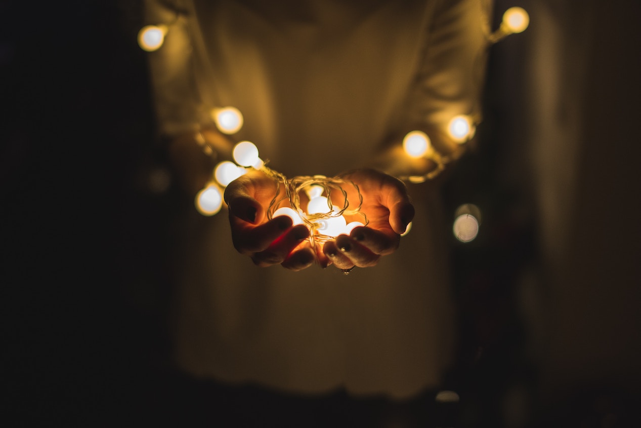 Hands holding string lights
