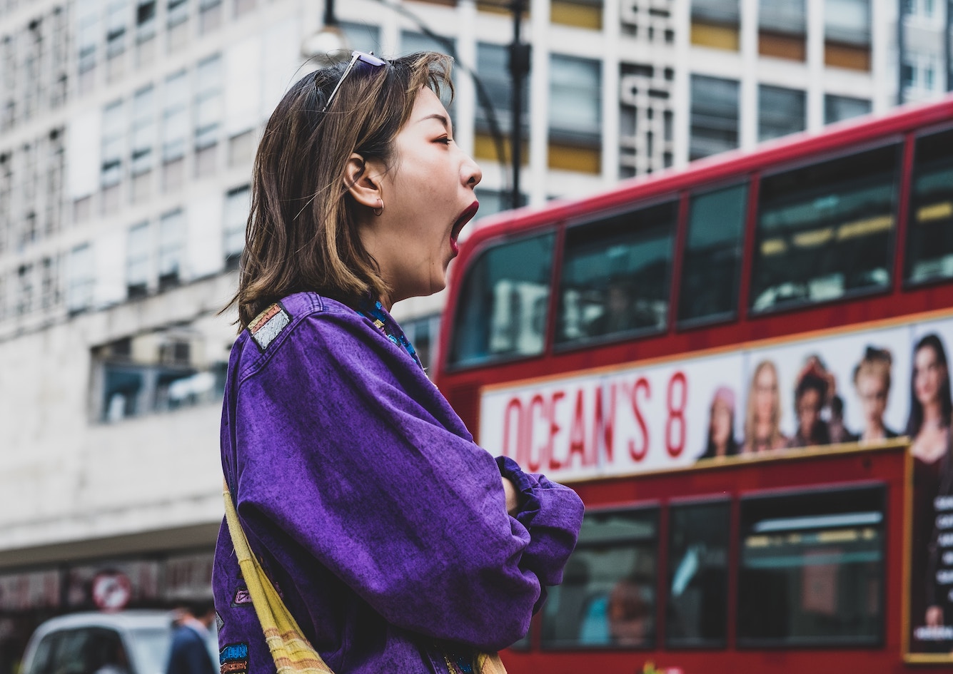 Woman in purple top yawning