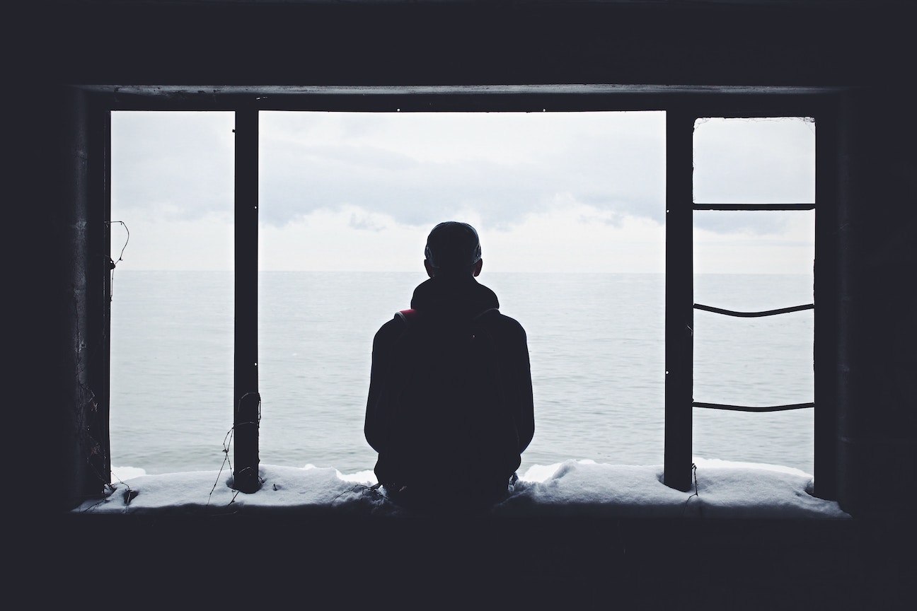 Silhouette of guy staring out window