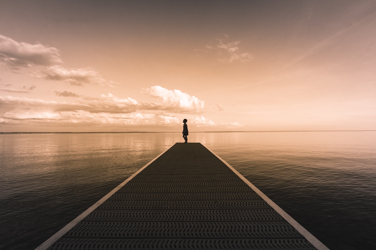 Boy at pier looking off into distance