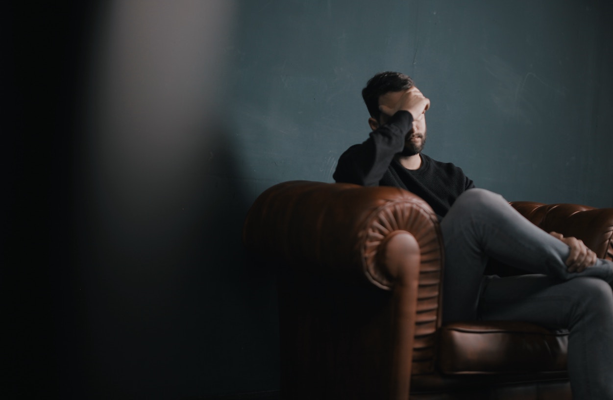 Man sitting on couch frustrated