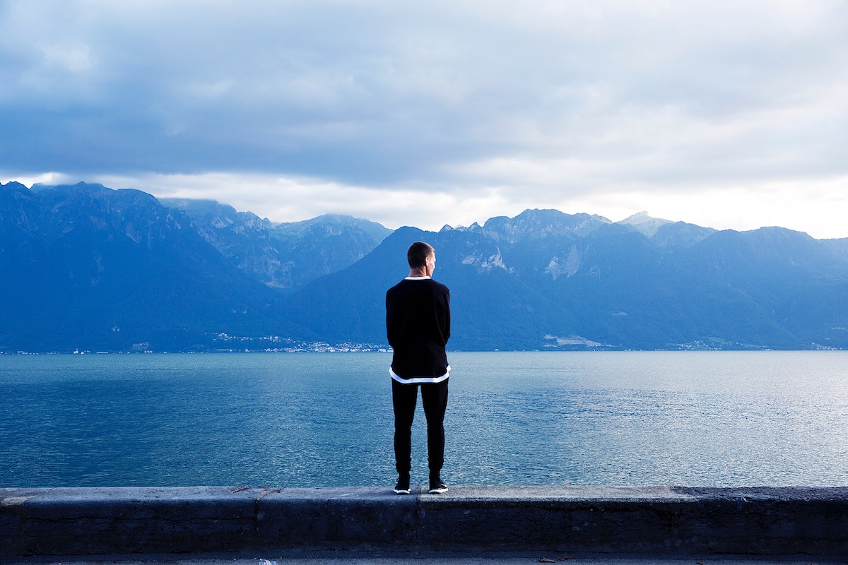 Man thinking with mountain and ocean backdrop