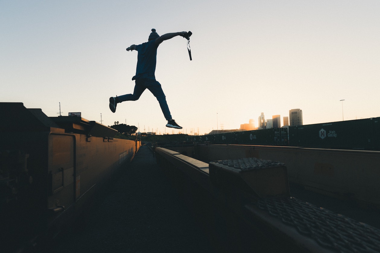 Man jumping across building roofs