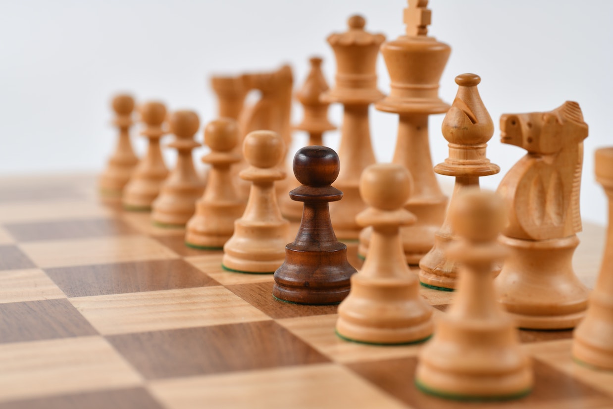 White chess pieces with one black piece