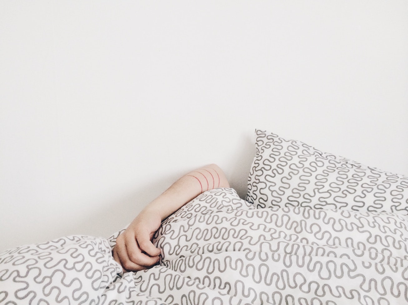 Hand sticking out from under the blanket
