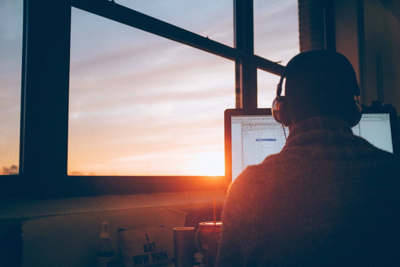 Man working on laptop during sunset
