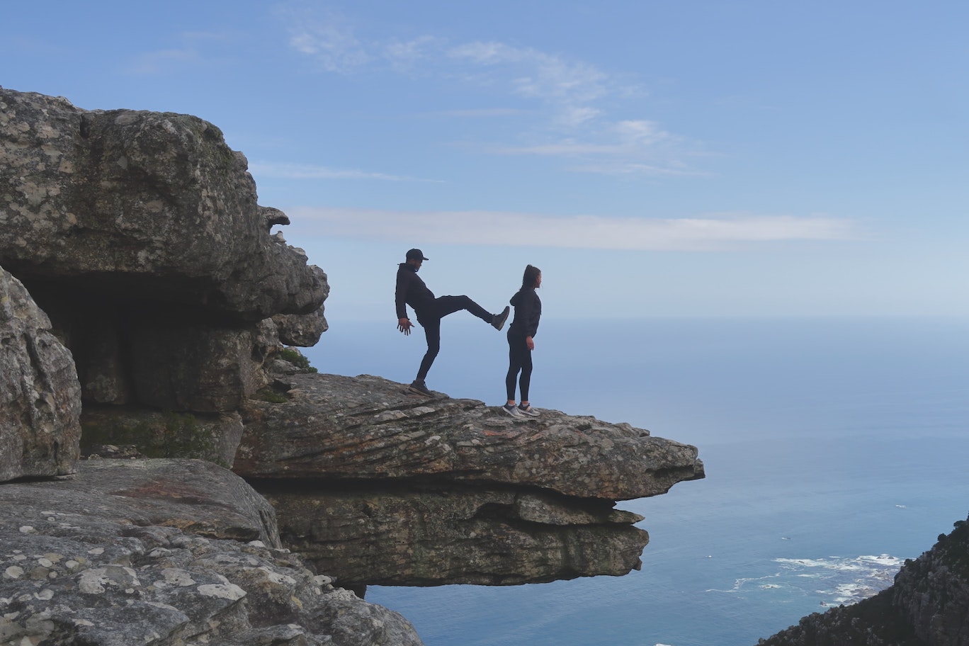 Man kicking woman off a cliff