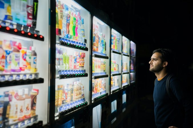 Man standing before vending machines