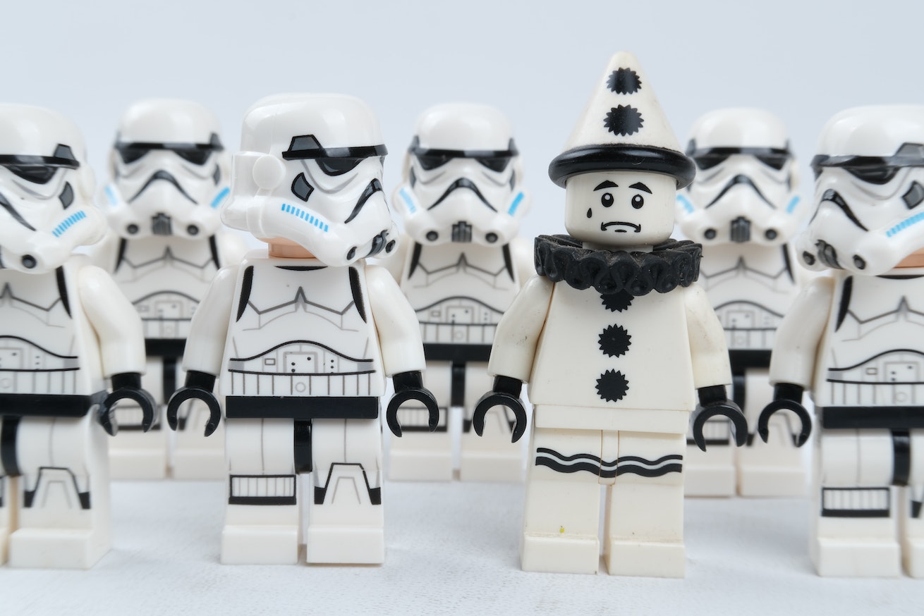 A group of Lego stormtroopers looking at the lone Lego mime