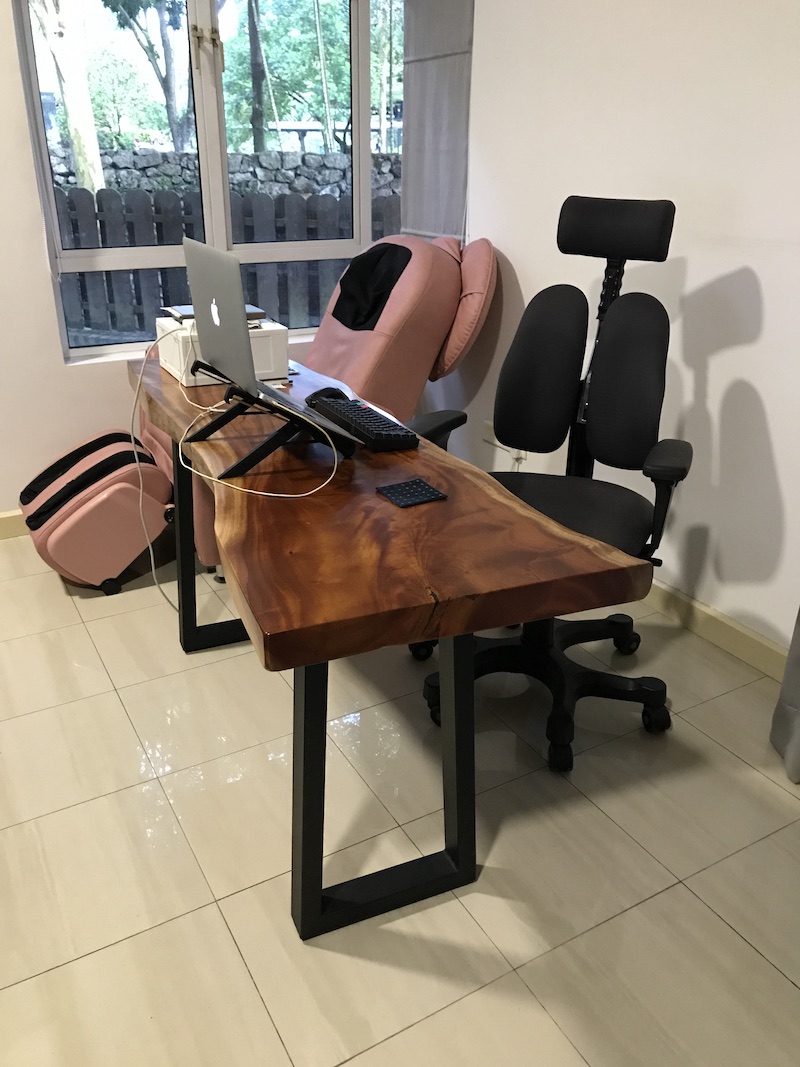 A photo of where I do most of my writing, consisting of my desk, laptop, and a window