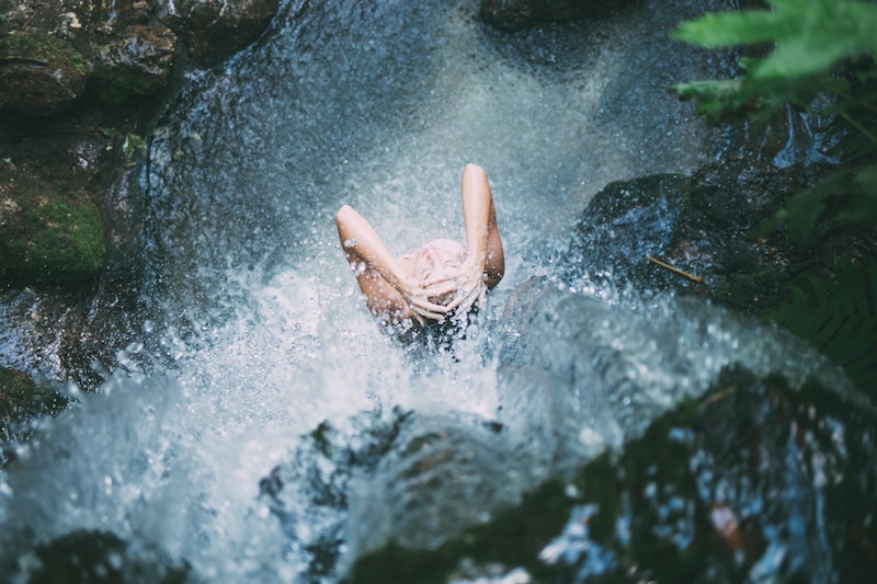 A woman bathing under waterfalls